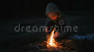 七岁的男孩在树林里生火。
